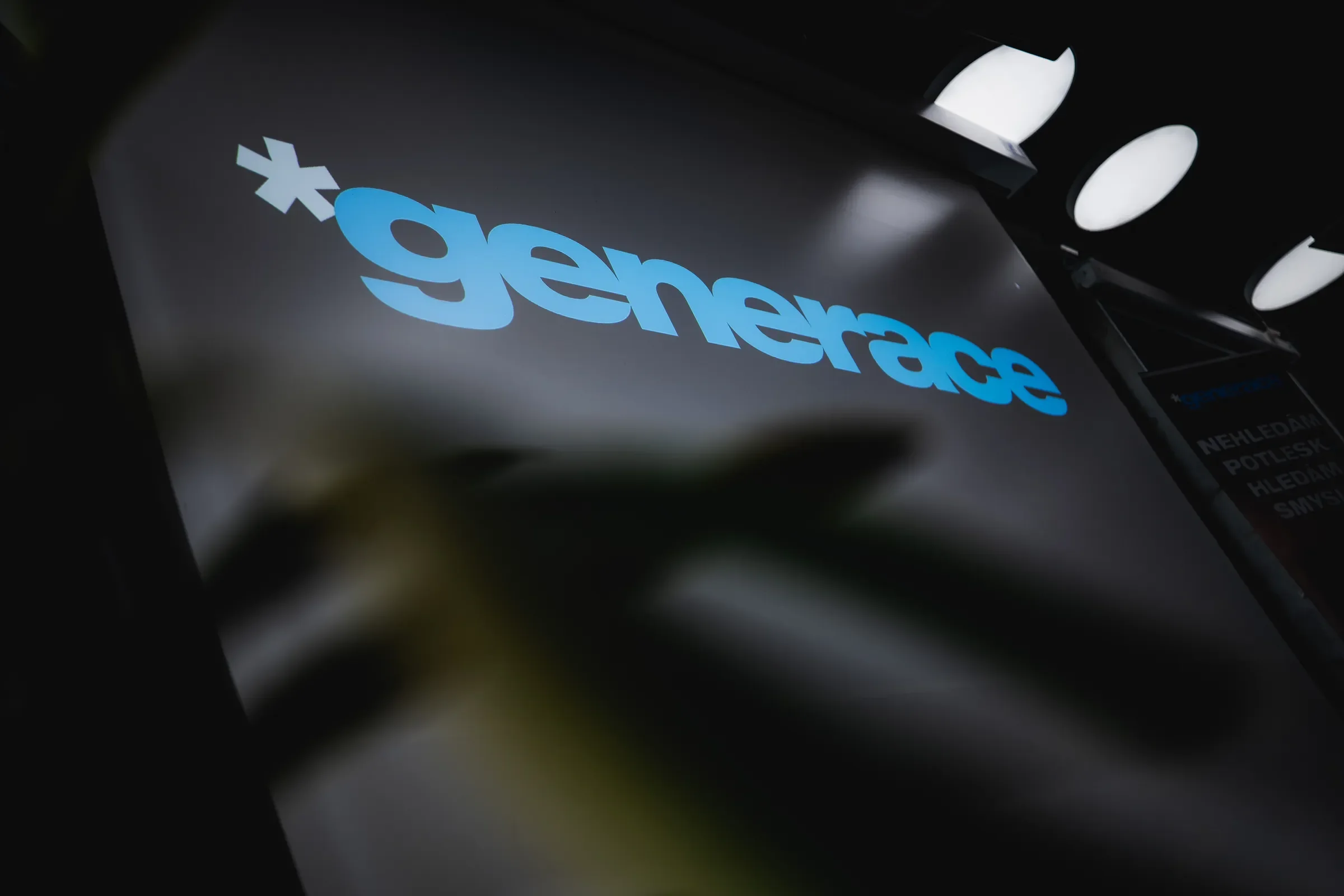 Logo Generace na tmavém panelu pódia